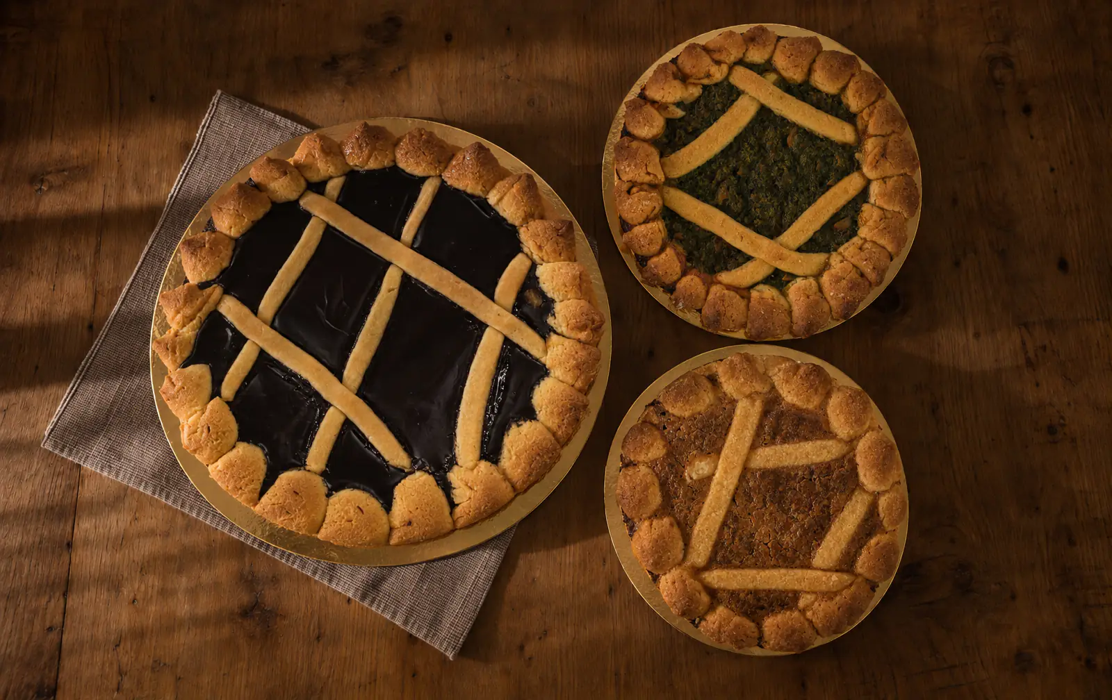 Le nostre torte coi becchi: una grande al cioccolato e due piccole, alle verdure e all’amaretto, su un tavolo di legno.
